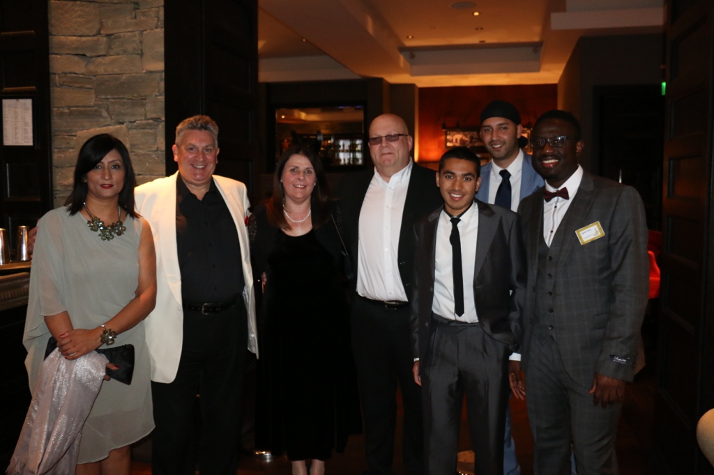 A group posing indoors in formal attire during the BT Exemplar recognition event